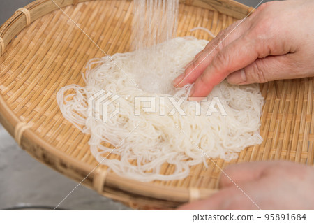 [Middle housewife cools boiled somen noodles with running water] 95891684