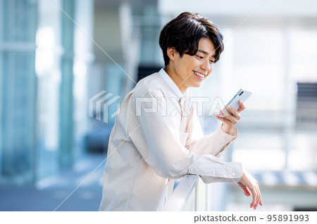 Young man operating a smartphone University student Young man operating a smartphone University student 95891993