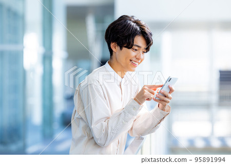 操作智能手機大學生的年輕人 操作智能手機大學生的年輕人 95891994