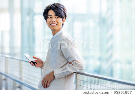 操作智能手機大學生的年輕人 95891997