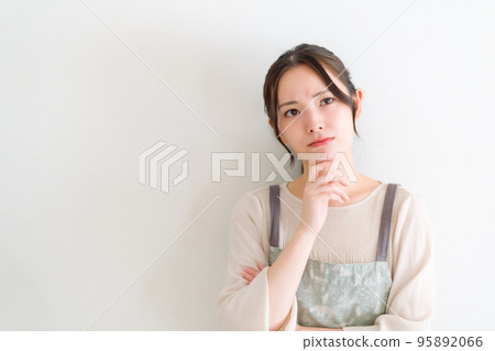 Young woman in an apron worries 95892066