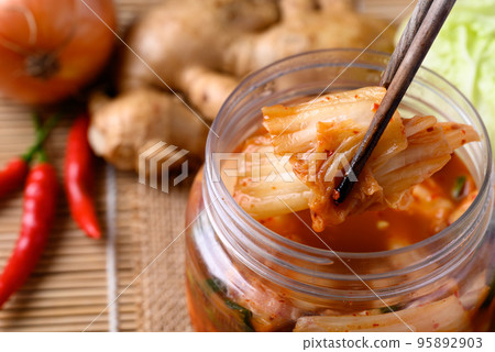 Kimchi cabbage in bowl eating by chopsticks, Asian fermented food Kimchi cabbage in bowl eating by chopsticks, Asian fermented food 95892903