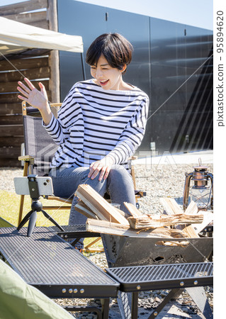 A woman live streaming a solo camp A woman live streaming a solo camp 95894620