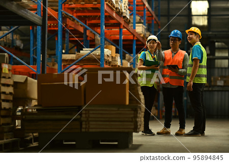 Warehouse workers working in the retail warehouse full of shelves with goods. Manufacture storehouse occupation concept Warehouse workers working in the retail warehouse full of shelves with goods. Manufacture storehouse occupation concept 95894845