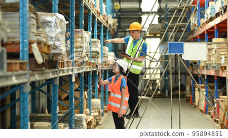 Warehouse workers working in the retail warehouse full of shelves with goods. Manufacture storehouse occupation concept Warehouse workers working in the retail warehouse full of shelves with goods. Manufacture storehouse occupation concept 95894851