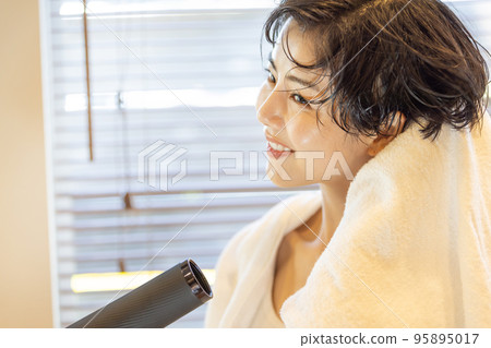一個女人乾燥她的頭髮 一個女人乾燥她的頭髮 95895017