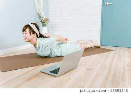 Asian woman in pajamas who trains her back at home/home gym (back squeeze) Asian woman in pajamas who trains her back at home/home gym (back squeeze) 95895248