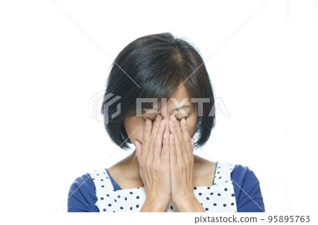 一個把手放在眼睛上的中年婦女 95895763