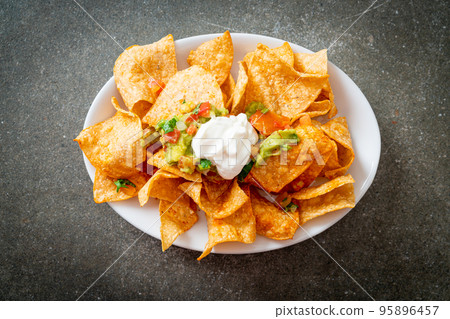 nachos tortilla chips with jalapeno, guacamole, tomatoes salsa and dip nachos tortilla chips with jalapeno, guacamole, tomatoes salsa and dip 95896457