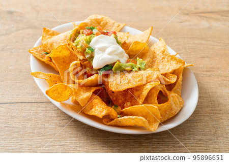 nachos tortilla chips with jalapeno, guacamole, tomatoes salsa and dip nachos tortilla chips with jalapeno, guacamole, tomatoes salsa and dip 95896651