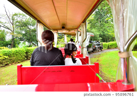 遊樂園火車上的父母和孩子 95896761