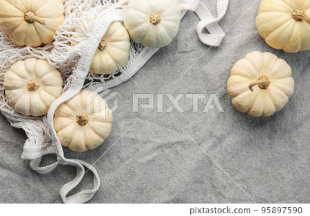 Top view autumn composition with pumpkins in mesh shopping bag 95897590