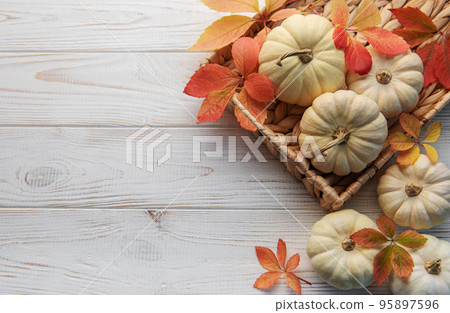 Autumn leaves and pumpkins over old wooden background 95897596