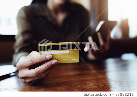 Portrait of young Asian woman using credit card and phone for online shopping. Portrait of young Asian woman using credit card and phone for online shopping. 95898218