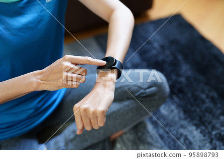 Health care, heart rate monitor, portrait of Asian beautiful woman using smart watch to select health programs such as yoga, cardio exercises, breathing meditation. to prepare before the activity. 95898793