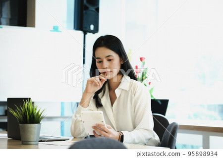 Business owners use calculators to calculate with financial documents to analyze third-party profits to invest in company stocks Business owners use calculators to calculate with financial documents to analyze third-party profits to invest in company stocks 95898934