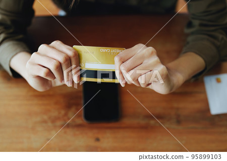 Portrait of a teenage Asian woman expressing dissatisfaction with her credit card being banned while using her phone for online shopping. Portrait of a teenage Asian woman expressing dissatisfaction with her credit card being banned while using her phone for online shopping. 95899103