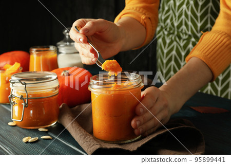 Concept of cooking, woman takes jam from a jar 95899441