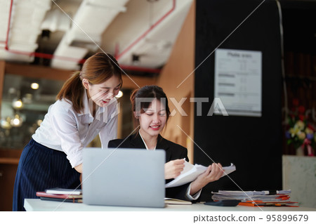A portrait of two young Asian businesswoman plan marketing strategies and investments to profit from their clients. A portrait of two young Asian businesswoman plan marketing strategies and investments to profit from their clients. 95899679