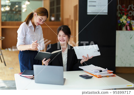 A portrait of two young Asian businesswoman plan marketing strategies and investments to profit from their clients. A portrait of two young Asian businesswoman plan marketing strategies and investments to profit from their clients. 95899717