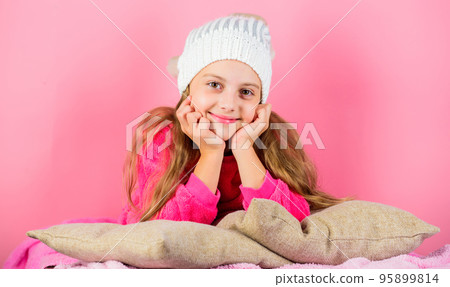 Winter fashion accessory. Kid girl knitted hat. Winter accessory concept. Girl long hair dream pink background. Kid dreamy lean on pillows. Winter season coziness attribute. Winter season concept 95899814