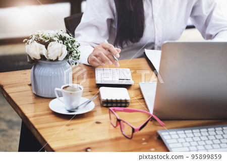 Business woman using calculator to review balance sheet annual using document and laptop computer to calculating budget. audit and Check integrity before investment concept 95899859
