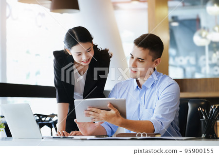 The male marketing manager expressed his satisfaction in selling the company's products. where team members show sales from their iPad screen 95900155