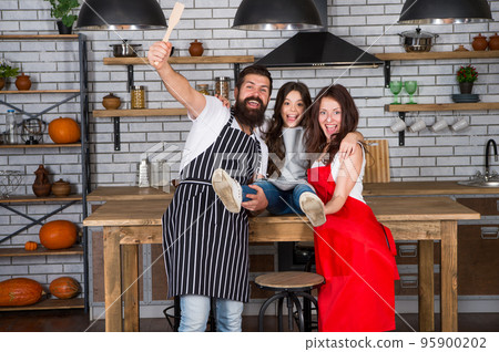 Cooking food concept. Prepare delicious meal. Breakfast time. Family having fun cooking together. Teach kid cooking food. Cooking together. Family mom dad and daughter wear aprons stand in kitchen 95900202