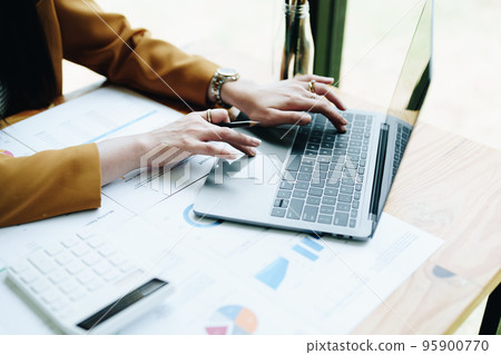 Portrait of a thoughtful Asian businesswoman looking at financial statements and making marketing plans using a computer on her desk. Portrait of a thoughtful Asian businesswoman looking at financial statements and making marketing plans using a computer on her desk. 95900770