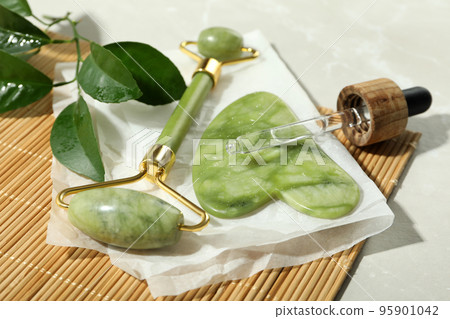 Face care concept with gua sha, face roller and cosmetic 95901042