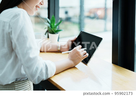 Portrait of a beautiful Asian teenage girl using a tablet computer. Portrait of a beautiful Asian teenage girl using a tablet computer. 95902173