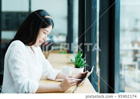 Portrait of a beautiful Asian teenage girl using a tablet computer. Portrait of a beautiful Asian teenage girl using a tablet computer. 95902174