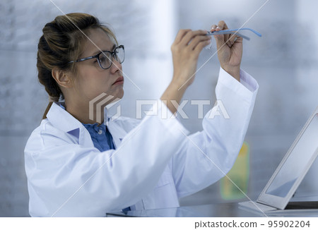An ophthalmologist is checking the glasses before delivering them. An ophthalmologist is checking the glasses before delivering them. 95902204