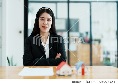 Guarantee, mortgage, contract, contract, signed, real estate agent or bank officer holding a calculator, submits a bid with a customer to buy a home before signing to make a deal. 95902524