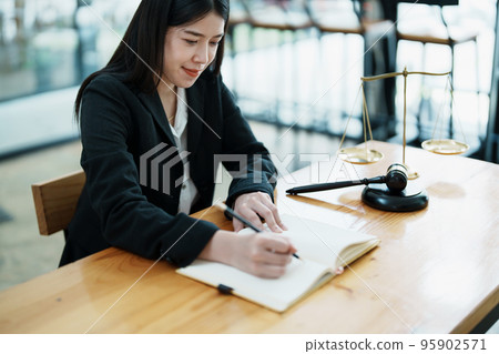 Portrait of a beautiful Asian lawyer studying a lawsuit for a client before going to court. Portrait of a beautiful Asian lawyer studying a lawsuit for a client before going to court. 95902571