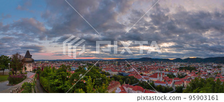 Cityscape of Graz and the clock tower (Grazer Uhrturm), famous tourist attraction on Shlossberg hill, Graz, Styria region, Austria, at sunset. Dramatic sky, panoramic view Cityscape of Graz and the clock tower (Grazer Uhrturm), famous tourist attraction on Shlossberg hill, Graz, Styria region, Austria, at sunset. Dramatic sky, panoramic view 95903161