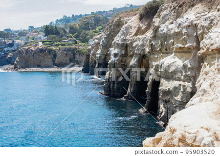 La Jolla sea caves with cliffside erosion and Sedimentary rock layers. Travelling and discovering California nature and geology La Jolla sea caves with cliffside erosion and Sedimentary rock layers. Travelling and discovering California nature and geology 95903520