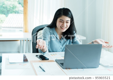 Portrait of a beautiful Asian teenage girl using computer for video conferencing at office. 95903521