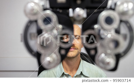 Young man checking his eyes to make glasses. Young man checking his eyes to make glasses. 95903714