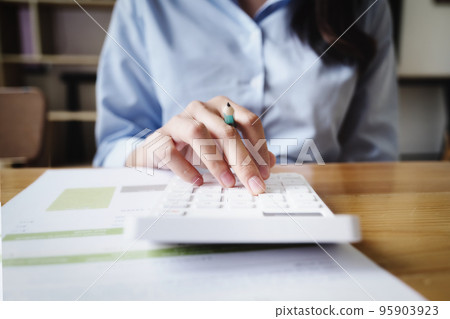 Business woman using calculator to review balance sheet annual using document to calculating budget. audit and Check integrity before investment concept 95903923