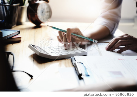 Business woman using calculator to review balance sheet annual using document to calculating budget. audit and Check integrity before investment concept 95903930