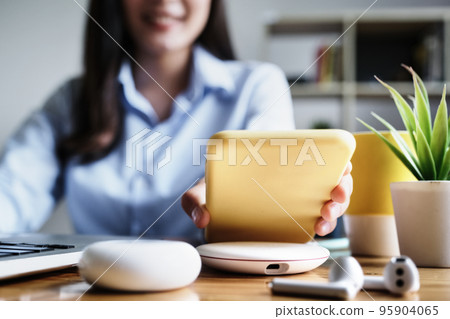 focus Female hand holding Smartphone to Charging at Wireless fast Charging pad at work. vintage tone focus Female hand holding Smartphone to Charging at Wireless fast Charging pad at work. vintage tone 95904065