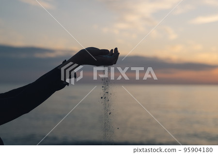 Hand of a woman who drops sand Hand of a woman who drops sand 95904180