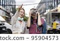 Two women of different nationalities travel happily. 95904573