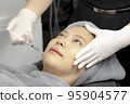 Experts perform injections for chin augmentation and anti-aging facials on young women, beauty clinics. 95904577