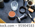 Close-up shot of Tamper coffee in basket, Slowbar coffee maker. 95904583