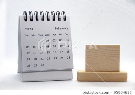 February 2023 white desk calendar on white background with customizable wooden space for text. 95904655