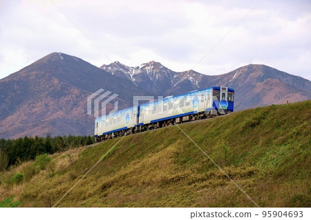 Kiha 110 series sightseeing limited express HIGH RAIL 1375 running on the Koumi Line's large embankment with Yatsugatake in the background Kiha 110 series sightseeing limited express HIGH RAIL 1375 running on the Koumi Line's large embankment with Yatsugatake in the background 95904693