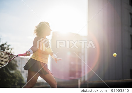 Caucasian mature woman playing tennis outside on sunny day. Caucasian mature woman playing tennis outside on sunny day. 95905840