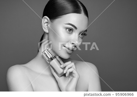 Portrait beautiful young woman with foundation bottle 95906966